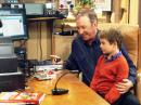 Tim Allen (L) as Mike Baxter, KAØXTT, sits in his ham shack with Flynn Morrison, who plays his grandson on the sitcom. [Photo courtesy of John Amodeo, NN6JA]